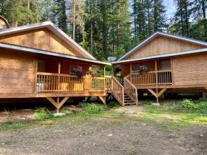 a log cabin with two decks in the woods at Last Spike Lodging in Malakwa