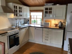 a kitchen with white cabinets and a stove top oven at 4 star holiday home in ELDSBERGA in Eldsberga +18 photos