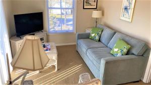 a living room with a couch and a flat screen tv at Somewhere In Time Unit 4 in Cape May Point