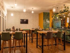 a restaurant with wooden tables and green chairs at Ibis Fes in Fez