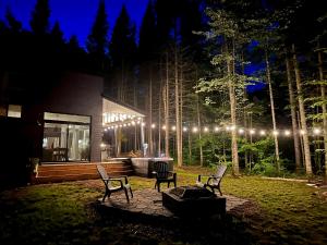 a couple of chairs sitting in a yard at night at Chalet Le St-Ray in Saint-Raymond