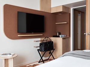 a bedroom with a flat screen tv on a wall at Pullman Paris Centre - Bercy in Paris