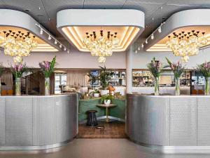 a restaurant with a bar with chandeliers at Pullman Paris Centre - Bercy in Paris +168 photos