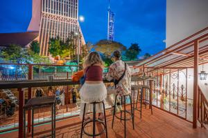 two people sitting at a bar on a balcony at Mingle Lekiu in Kuala Lumpur