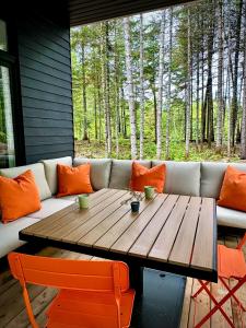 a couch and a wooden table with orange pillows at Chalet Le St-Ray in Saint-Raymond