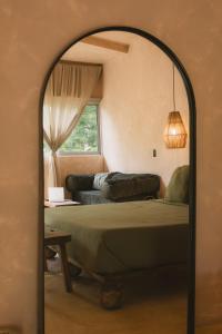 a bedroom with a bed and a couch and a mirror at Ánimo Perro in Sayulita