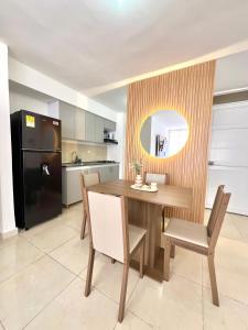 a kitchen with a wooden table and a black refrigerator at Apartamento para Descansar en Valledupar in Valledupar