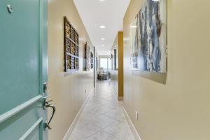 a hallway with a blue door and paintings on the walls at XL Terrace, Lazy River, I-O Pools, Game Room, Spa, Beach, Luxury 2-2 Penthouse! in Galveston
