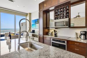a kitchen with a sink and a counter top at XL Terrace, Lazy River, I-O Pools, Game Room, Spa, Beach, Luxury 2-2 Penthouse! in Galveston