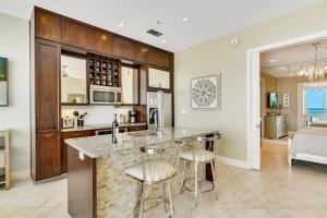 a kitchen with a counter and stools in a room at XL Terrace, Lazy River, I-O Pools, Game Room, Spa, Beach, Luxury 2-2 Penthouse! in Galveston +53 photos