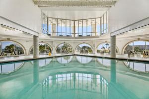 an indoor swimming pool with blue water in a building at XL Terrace, Lazy River, I-O Pools, Game Room, Spa, Beach, Luxury 2-2 Penthouse! in Galveston
