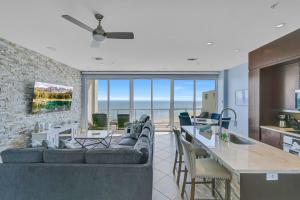 a living room with a couch and a kitchen with a view at PH, Balcony, Lazy River, I-O Pools, Game Room, Spa, Beach, Luxury 2-2 Penthouse! in Galveston +56 photos