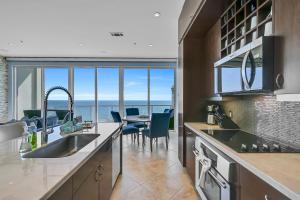 a kitchen with a view of the ocean at PH, Balcony, Lazy River, I-O Pools, Game Room, Spa, Beach, Luxury 2-2 Penthouse! in Galveston