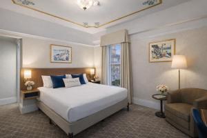 a hotel room with a bed and a chair at Cornell Hotel Union Square in San Francisco