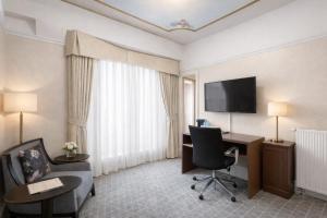 a hotel room with a desk and a tv at Cornell Hotel Union Square in San Francisco