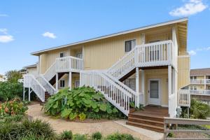a house with white stairs on a beach at Waterfront Summer Vacay Free Private Beach Chairs & Umbrella Sleeps 5 in Destin