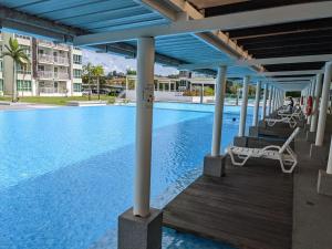 a swimming pool with a deck and chairs next to a building at Private Room in Condominium - Sandakan Friend House in Sandakan