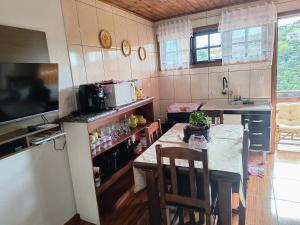 a kitchen with a table and a dining room at Casa de Boneca in Campos do Jordão +17 photos
