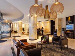 a lobby with couches and chairs in a building at Novotel London Tower Bridge in London