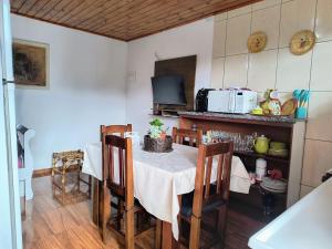 a kitchen with a table with chairs and a microwave at Casa de Boneca in Campos do Jordão