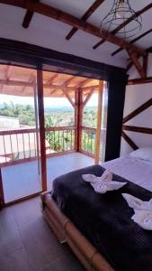 a bedroom with a bed with a view of a balcony at Apto/cabaña naranja in Ulloa
