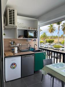 a kitchen with a view of a parking lot at Kéloué in Saint-François