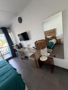 a bedroom with a bed and a desk and a mirror at Kéloué in Saint-François