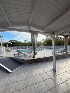a patio with chairs and a pool in the background at Kéloué in Saint-François