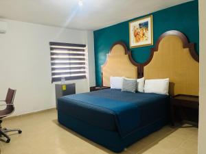 a bedroom with a blue bed and a chair at Hotel Palmeras Los Cabos in Cabo San Lucas +10 photos