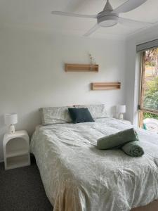 a bedroom with a white bed with a ceiling fan at Sapphire House in Mirador