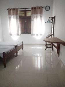 a bedroom with a bed and a chair and a window at Green Haven by Gapper Sri Lanka in Wattala