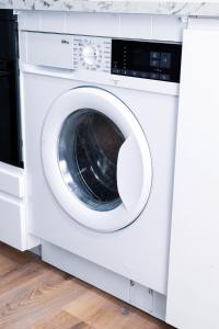 a white washing machine sitting in a room at Cozy Apartment in Dublin