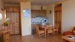 a kitchen and dining room with a table and chairs at Apartmány Bea Donovaly in Donovaly