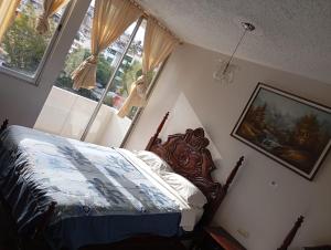 a bedroom with a bed in a room with windows at HOTEL SARAGURO LOJA in Loja