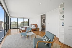 a living room with a bed and chairs and a table at Mirani's Penthouse in Port Adelaide