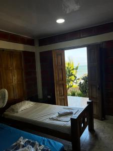 a bedroom with a bed and a view of the ocean at Cabañas Cambaro in Puerto Escondido