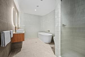 a bathroom with a tub and a toilet and a sink at Mirani's Penthouse in Port Adelaide +6 photos