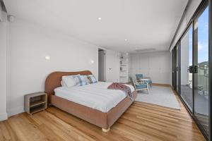 a bedroom with a bed and a large window at Mirani's Penthouse in Port Adelaide