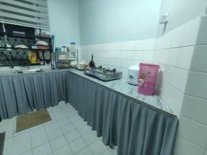 a kitchen with a counter top with a sink and a counter sidx sidx at Laman Biru Azalea in Pekan