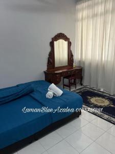 a bedroom with a bed with a mirror and a dresser at Laman Biru Azalea in Pekan +1 photo