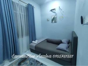 a blue room with a bed and a window at Laman Biru Azalea in Pekan