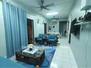 a living room with blue chairs and a table at Laman Biru Azalea in Pekan