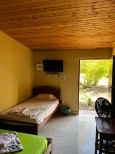 a bedroom with a bed and a flat screen tv at Cabañas Cambaro in Puerto Escondido