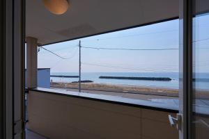 a view of the ocean from a bathroom window at TOYA Station Villa in Lake Toya