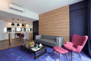 a living room with a couch and two pink chairs at Amerin Hotel Johor Bahru in Johor Bahru