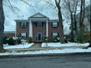a red brick house with snow on the ground at Downtown Halifax suites in Halifax