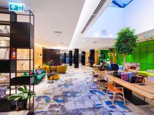 a lobby of a hotel with chairs and tables at Mercure Warszawa Grand in Warsaw