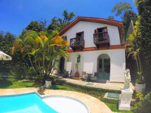 una casa con piscina frente a ella en Pousada Imperial Koeler, en Petrópolis