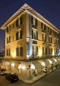 a large building with cars parked in front of it at Hotel Florida in Montecatini Terme