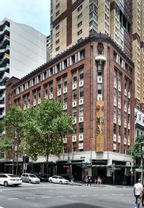 un grande edificio in mattoni su una strada di città con automobili di The Pod Sydney a Sydney